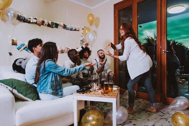 A group of young people celebrating and making party at home