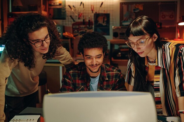 Group of young people developing new computer program they watching presentation on computer