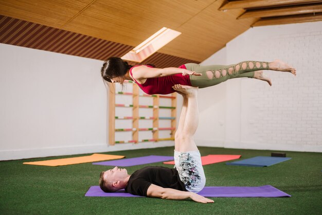 A group of young people doing yoga exercises indoors at the gym