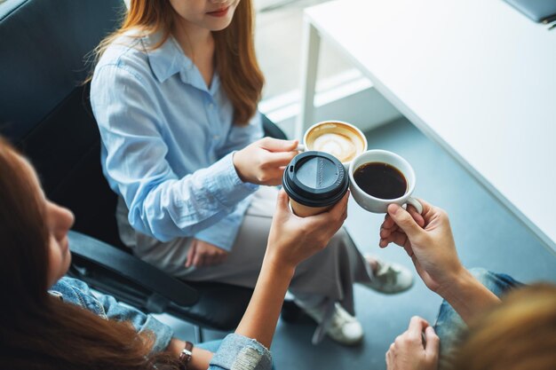 Foto un gruppo di giovani si è divertito a bere e tintinnare tazze di caffè al bar