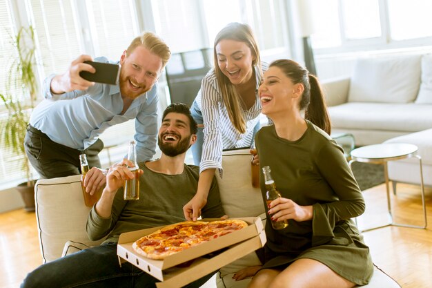 Photo group of young people having pizza party