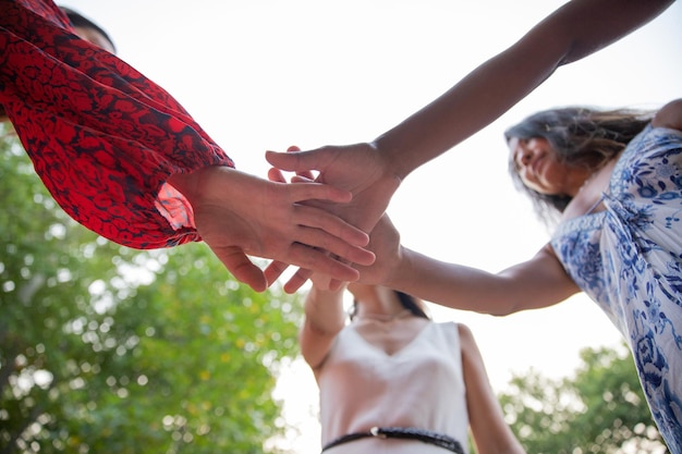 Group of young people joining hands to manifest the power of friendship