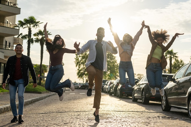 Group of young people jumping and laughing in a city street, happy students celebrating the achievements obtained