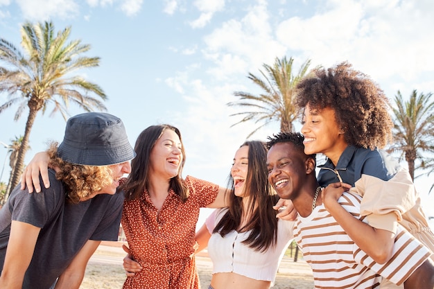 Group of young people laughing and having fun outside a beach town summer concept multiethnic integr...