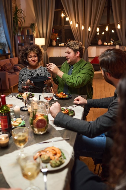 Group of young people playing game during a dinner in the living room