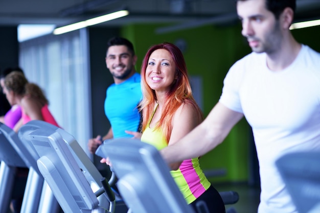 group of young people running on treadmills in modern sport  gym