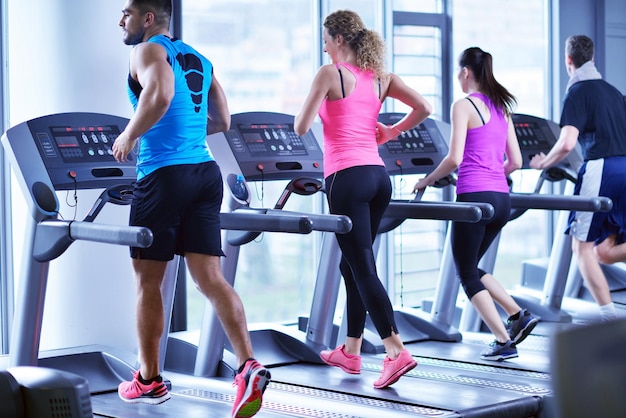 group of young people running on treadmills in modern sport  gym