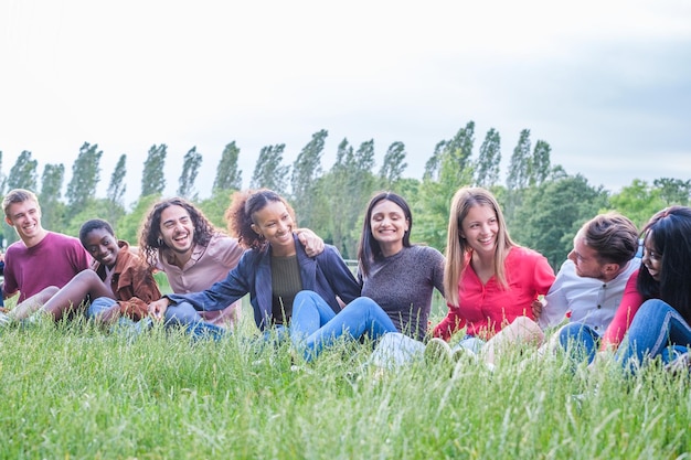 Group of young people spending some free time together and having fun in the park by the river