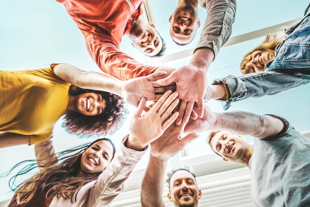 Group of young people stacking hands together outdoor