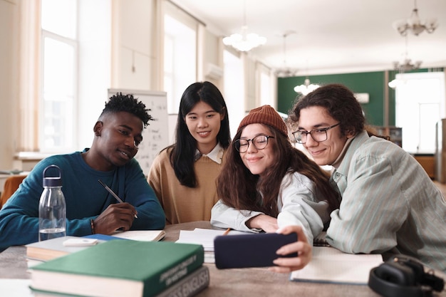 Group of young people taking selfie in library