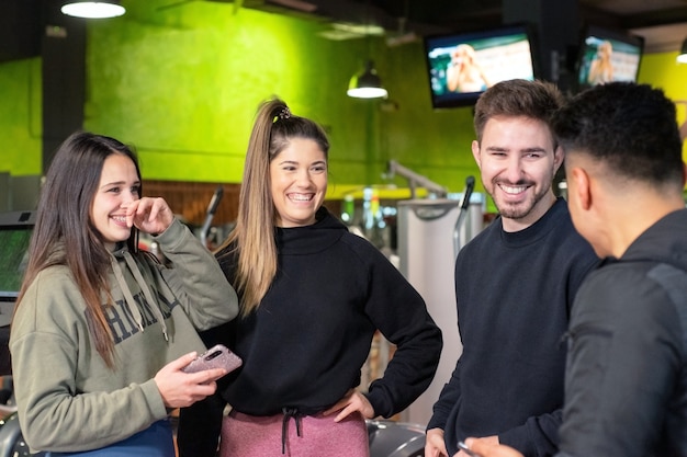 Gruppo di giovani che utilizzano e che guardano insieme il telefono cellulare.