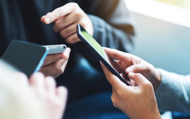 Group of young people using and looking at mobile phone together