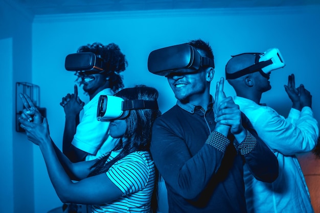 Group of young people in vr glasses in a virtual reality game in a blue light with guns futuristic or science technology concept