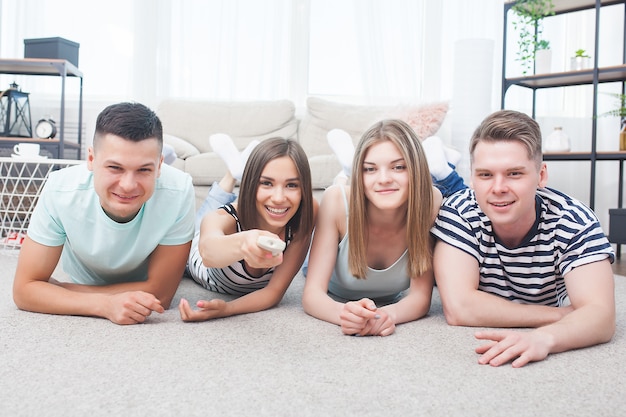 Group of young people watching tv. Emotional friends having fun and watching game indoors.