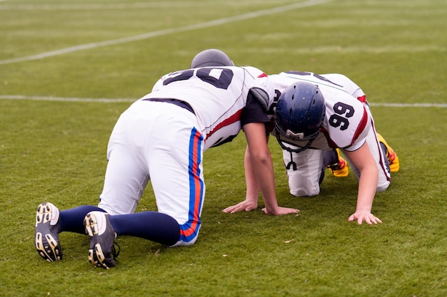 Group of young professional american football players in action\
during training on the field