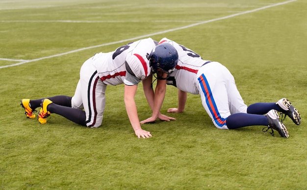 Group of young professional american football players in action\
during training on the field