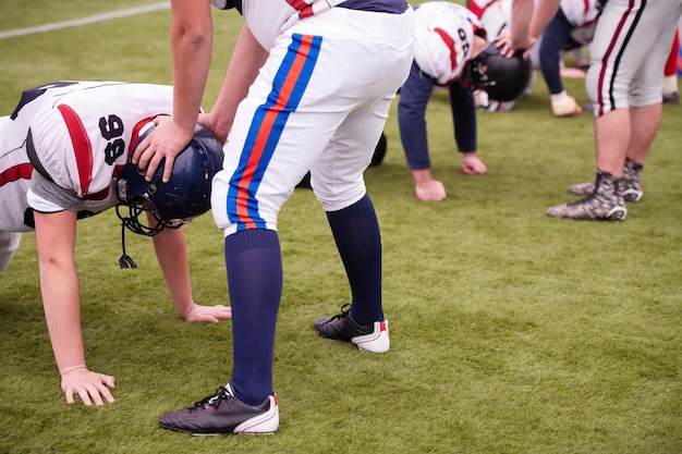 Group of young professional american football players in action\
during training on the field