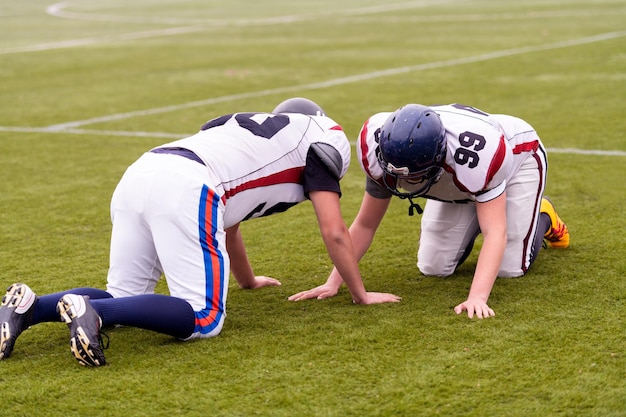 Group of young professional american football players in action\
during training on the field