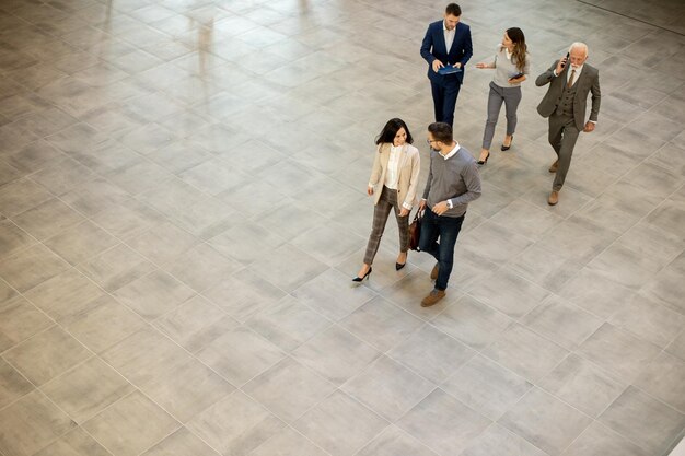 Un gruppo di uomini d'affari giovani e anziani sta camminando nel corridoio di un ufficio