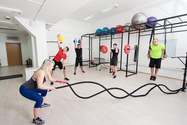 Group of Young Sporting Adults Training on Athletic Field Against Barred Window