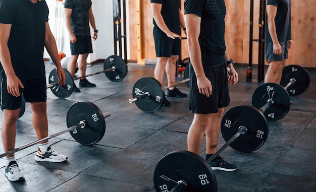 Group of young sportive people have crossfit day indoors in gym