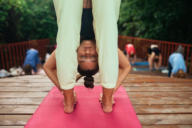 Group of young sporty people practicing yoga lesson with instructor