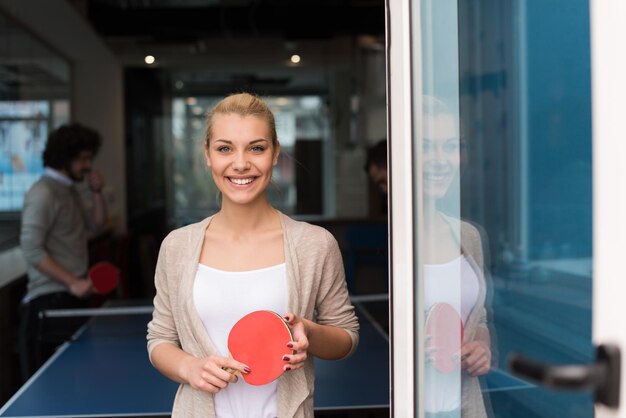 group of young startup business people playing ping pong tennis at modern creative office