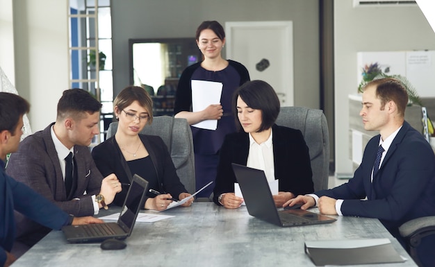 Photo group of young successful businessmen lawyers communicating together in a conference room while working on a project