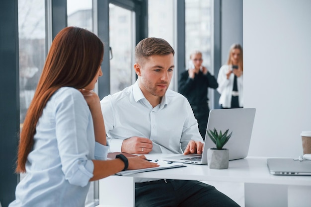 Gruppo di giovani team di successo che lavorano e comunicano insieme al chiuso in ufficio