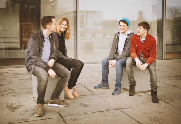 Group of young teenage friends talking and laughing together