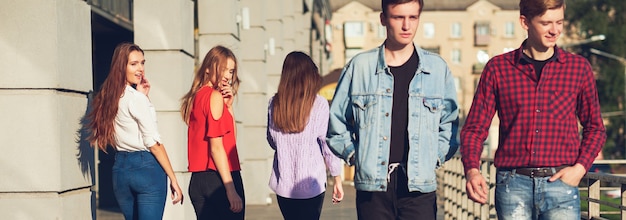 Photo group of young woman flirting with men in city.