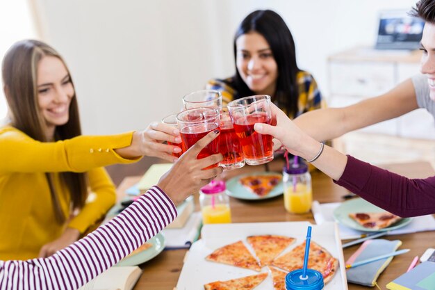 Group of young women at home clinking glasses