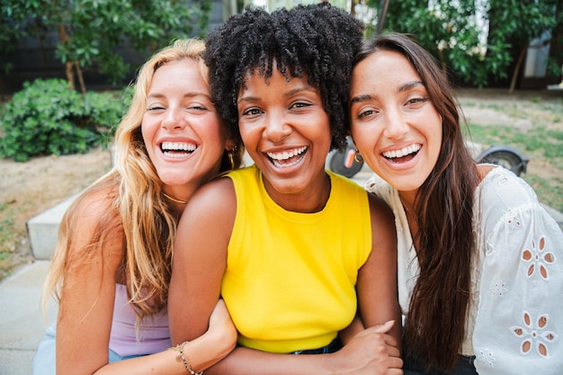group of young women smiling and looking at camera three multiracial teenage girls having fun
