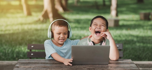 Groups of children sitting in their gardens Children happily playing computer games