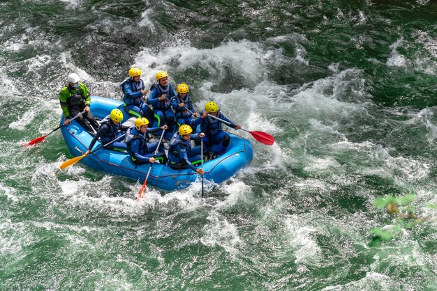 Foto gruppi di giovani amici si divertono a fare rafting sulle rapide del fiume