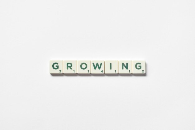 Growing formed of scrabble blocks on white background