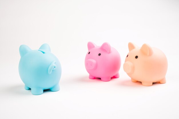 Growing investment - three piggy banks different color isolated on white