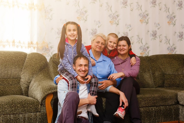 Grown up adult smiling grandchildren embraces elderly grandmother glad to see missing her, visit of loving relatives enjoy communication, cuddle as symbol of connection, love and support concept