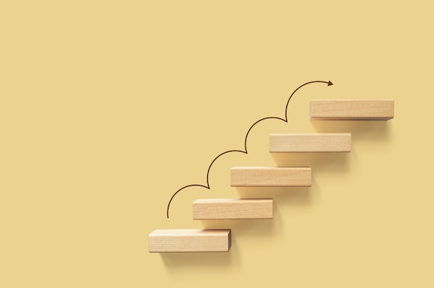 Фото Рост или увеличение концепции дизайна. ступенька лестницы кубического блока движется вверх к цели. достижение успеха или бизнес-мотивация цели