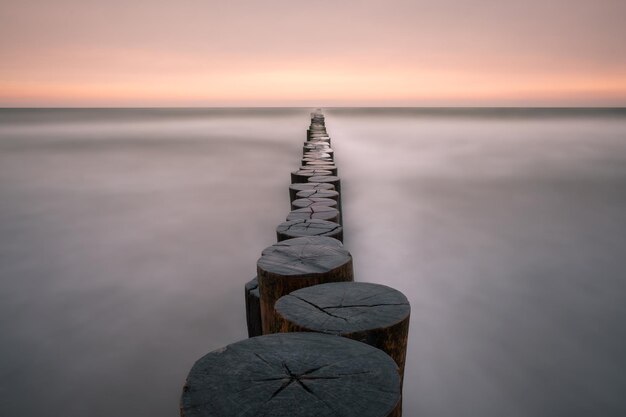 해가 지는 동안 조용한 바다에서 해변에서 Groynes