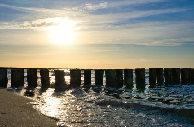 Groynes jut into the sea at sunset The sun shines on the Baltic Sea Landscape