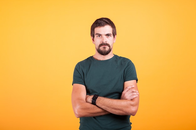 Grumpy stressed worried man on yellow background lookin at the camera. Depression, unhappy and stress concept image