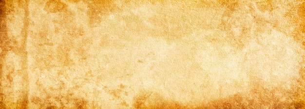 Grunge background banner of old brown paper in spots and streaks for design and text