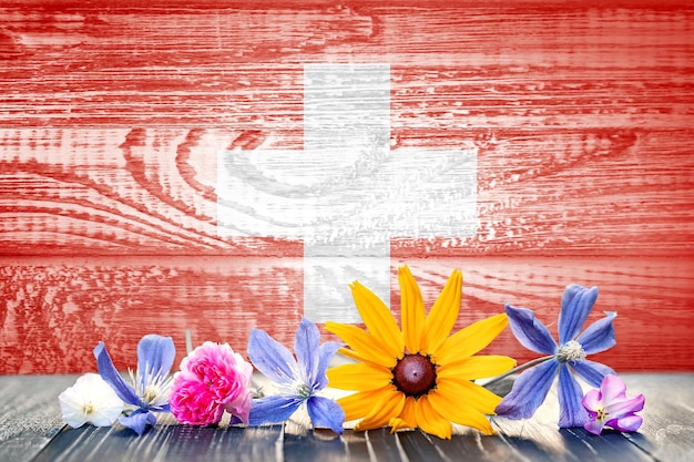 Grunge flag of Switzerland with wildflowers Wood texture Background for design and text