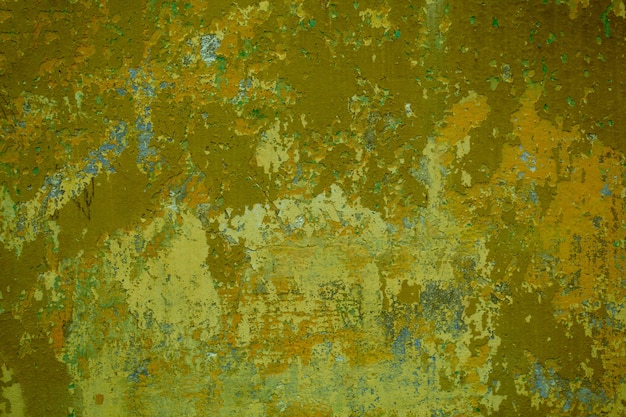 Grungy cement wall with cracks and old dingy green paint remnants in a full frame view.