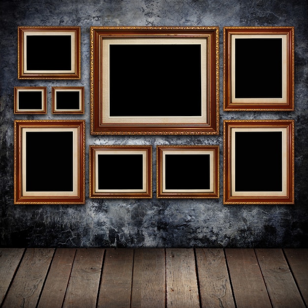 Grungy muur met gouden frames en oud hout