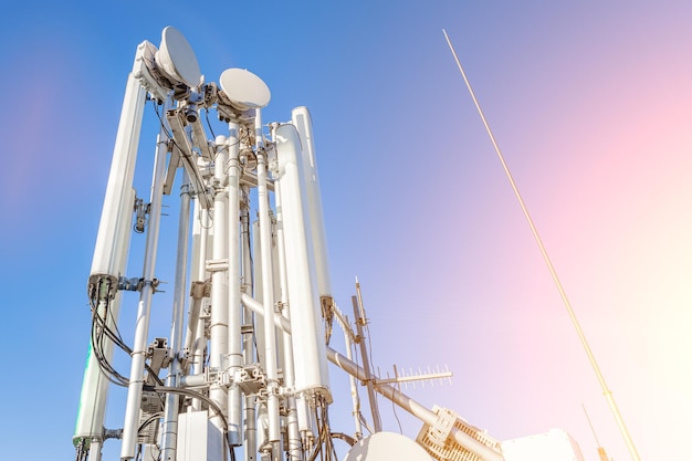 GSM antennas on a high tower against the blue sky 5g 4g antennas for cellular communication closeup plan