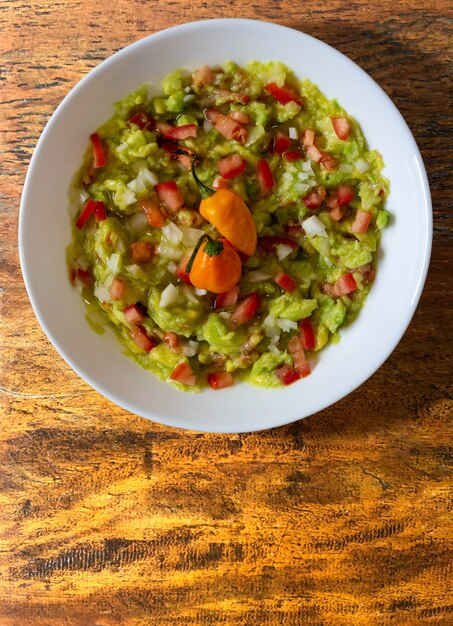 Guacamole bowl on wooden table - top view