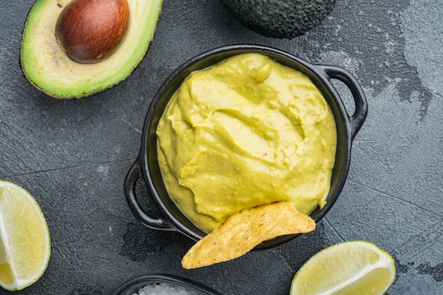 Guacamole freshly cooked and served in bowl, on gray table, top view or flat lay