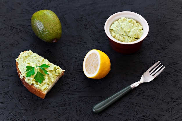 Guacamole sandwich. Citroen, avocado op een zwarte achtergrond